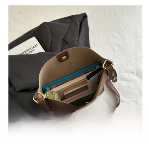 Détail de l'intérieur d'un grand sac seau marron foncé avec capacité pour tablette et parapluie