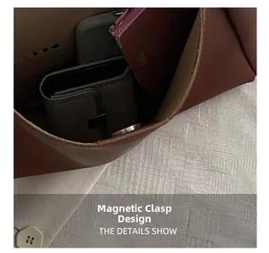 Detail view of large brown bucket bag interior featuring secure magnetic buckle closure