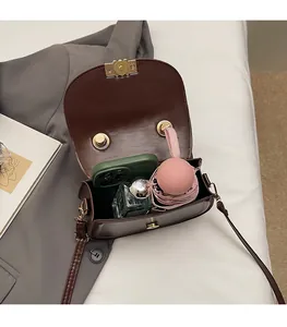 Détail de l'intérieur spacieux du sac besace marron avec un parapluie pliable