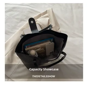 Spacious interior of black tote bag showing tablet, umbrella, and daily essentials