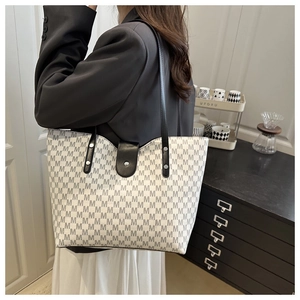 Detail of minimalist tote bag with monogram print and secure magnetic button closure