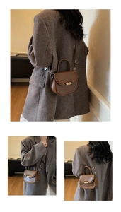 Detail view of brown leather saddle bag featuring gold metal buckle and side strap texture