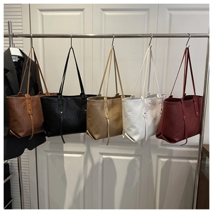 Close-up of five woven tote bags in brown, black, khaki, white and burgundy colors