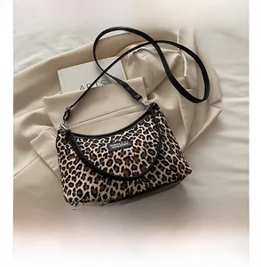 Detailansicht der Schultertasche mit Leopardenmuster, schwarzem Riemen und Metallbeschlägen