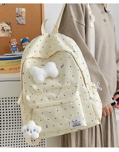 Détail du sac à dos à pois avec nœud en peluche et pendentif étoile sur un modèle