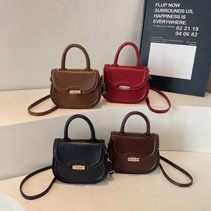 Minimalist faux leather saddle bags in four colors with gold metal clasps and top handles