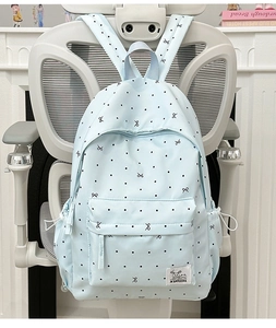 Vue détaillée du sac à dos à pois bleu clair montrant les poches latérales à cordon serrage