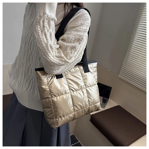 Sac fourre-tout matelassé doré porté à l'épaule pour un look décontracté chic