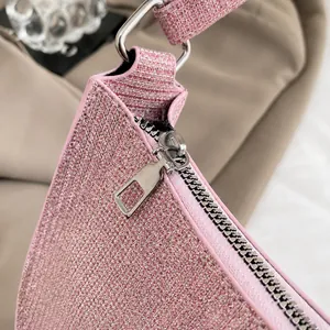 Macro shot of smooth silver metal zipper and pink glitter texture on the stylish handbag