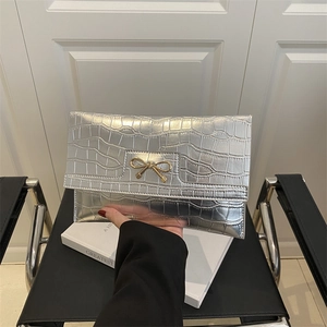 Ασημί τσαντάκι clutch με σχέδιο κροκόδειλου και χρυσή αγκράφα με φιόγκο