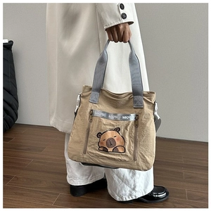 Detail of khaki nylon bucket bag with cute capybara print and side zipper pockets