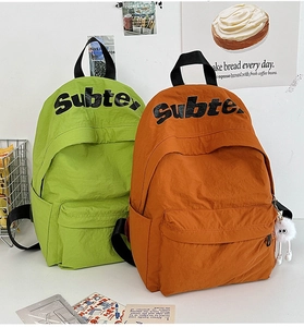 Dettaglio di zaini in nylon verde e arancione con stampa di lettere Subte alla moda