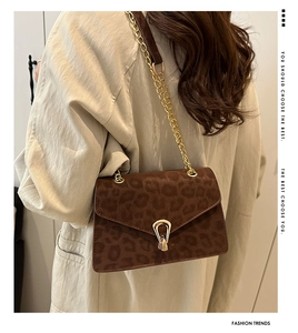 Detail of leopard print suede crossbody bag with gold chain and metal lock buckle