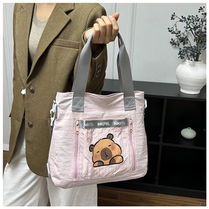 Detailed view of pink nylon bucket bag featuring a cute sleeping capybara cartoon print