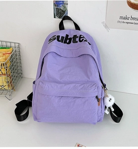 Dettaglio dello zaino in nylon viola con stampa subte e ciondolo in peluche