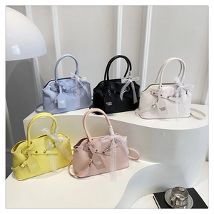 Détail de sacs à main en cuir en cinq couleurs avec nœuds en dentelle et étiquettes de marque