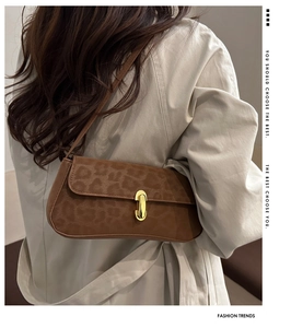 Détail du sac bandoulière imprimé léopard avec fermoir doré et trench-coat beige