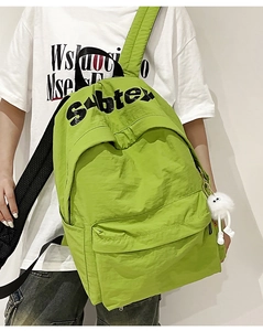 Dettaglio dello zaino in nylon verde con stampa Subtex e un simpatico mostro di peluche