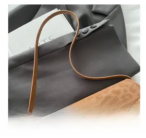 Vue détaillée du sac à bandoulière en daim marron avec boucle métallique dorée