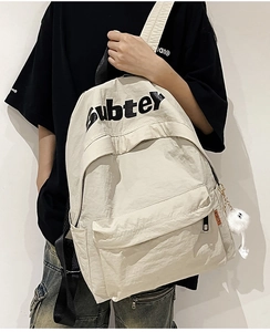 Vista laterale dello zaino in nylon beige con stampa Subter ed etichetta arancione