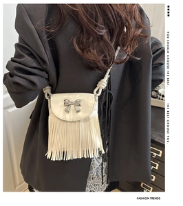 Détail du sac bandoulière crème avec nœud argenté et longues franges décoratives