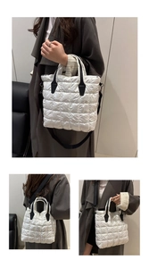 Détail du sac cabas matelassé blanc avec poignées en cuir noir et bandoulière réglable