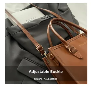 Gros plan de la boucle métallique réglable et de la bandoulière en cuir d'un sac marron