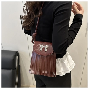 Détail du sac bandoulière bordeaux avec nœud argenté et longues franges