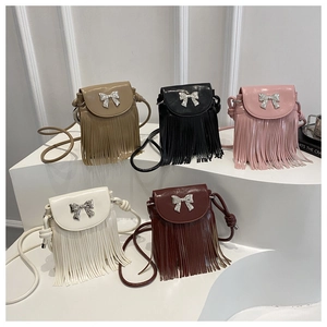 Détail de cinq sacs bandoulière avec nœuds métalliques et franges longues élégantes