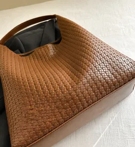 Macro shot of brown woven leather texture and interior space of a hobo tote bag