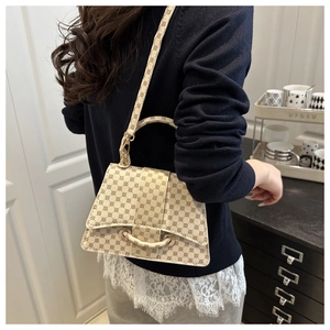 Detailweergave van beige monogram crossbodytas met leren riem en handvat aan de bovenkant