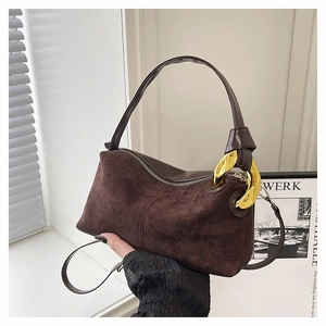Gros plan sur un sac à main en daim marron foncé avec de grands maillons de chaîne dorés