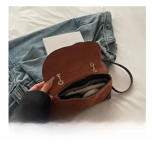 Interior view showing the capacity of this brown suede crossbody bag with gold hardware