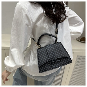 Detail van donkergrijze geometrische crossbodytas gedragen met casual kleding