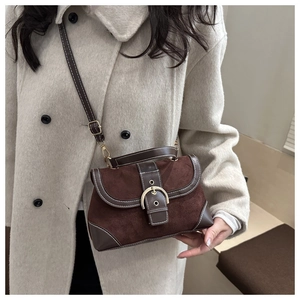Detail of vintage brown suede crossbody bag with gold buckle and white contrast stitching