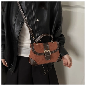 Detailed shot of brown vintage handbag with gold buckle and adjustable strap