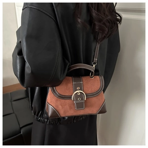 Detailed view of vintage crossbody bag with brown suede and leather stitching accents
