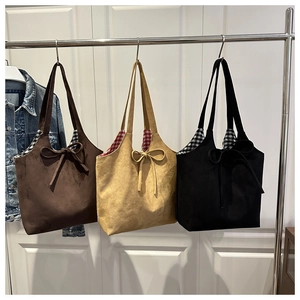 Close-up of retro suede tote bags with bow detailing and checkered lining interior