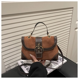 Detail of vintage brown suede crossbody bag with gold ring buckle and white stitching