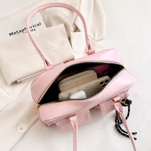 Interior view of pink leather handbag showing capacity for phone, wallet, and earbuds