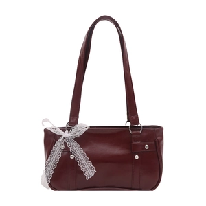 Bolso baguette de cuero rojo oscuro con lazo de encaje blanco y remaches sobre fondo blanco