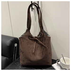 Brown suede tote bag with decorative bow and black and white checkered lining