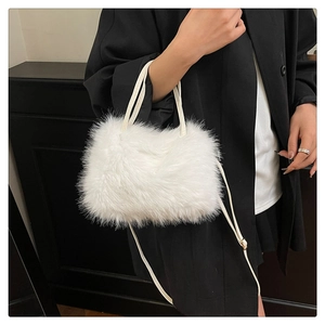 Dettaglio borsa bianca in ecopelliccia con tracolla su modella con cappotto nero