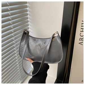 Détail du sac baguette en cuir verni gris avec finition brillante et fermoir doré