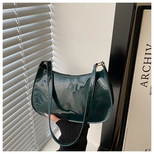 Détail du sac à bandoulière en cuir verni vert foncé avec finition brillante et zip