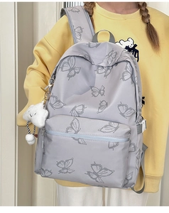 Detail of grey butterfly print backpack with waterproof fabric and cloud plush charm