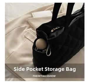Détail de la poche latérale d'un grand sac cabas matelassé noir avec parapluie