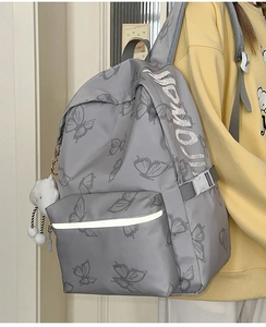 Detail of grey butterfly backpack with reflective strip and white cloud plush charm