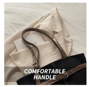 Detailweergave van contraststiksels en verstelbare leren riem op de canvas tas