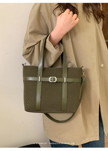 Détail du sac fourre-tout vert foncé avec œillets porté avec un trench-coat beige